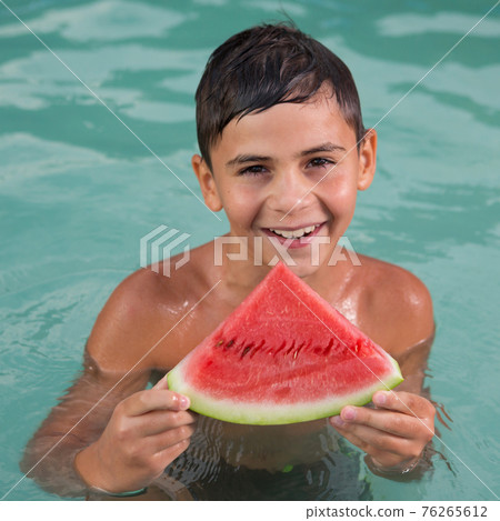happy boy with a slice of watermelon while in the water, summer and vacation concept happy boy with a slice of watermelon while in the water, summer and vacation concept 76265612