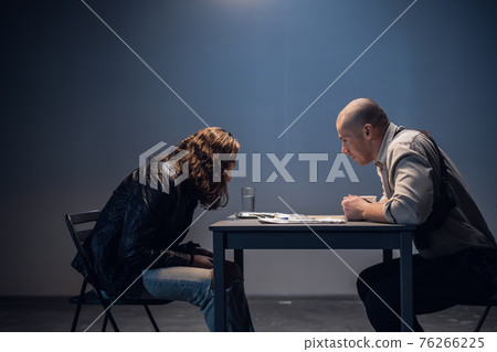 A police detective suspects a white man of committing a crime. Conducts an interrogation with the presentation of evidence in the interrogation room. A police detective suspects a white man of committing a crime. Conducts an interrogation with the presentation of evidence in the interrogation room. 76266225