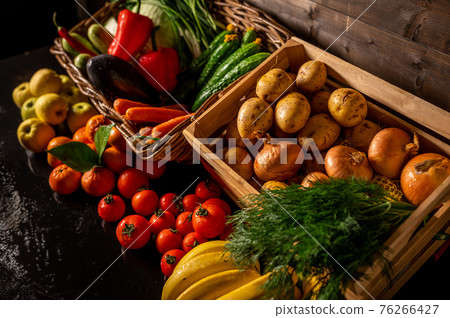 Fresh vegetables in a wooden box on a wooden background. Fruits and vegetables market 76266427