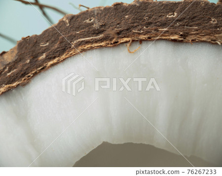 Closeup texture of a cutaway coconut fruit on a blue background. 76267233
