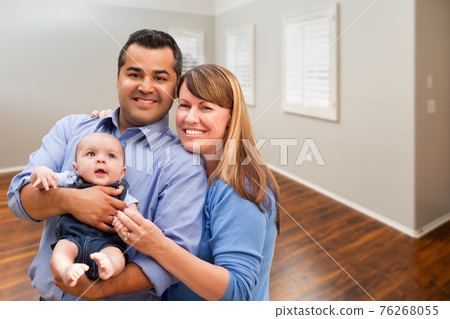 Young Couple With Baby In Empty Room of New House 76268055