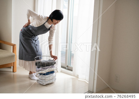 一位腰痛和背部緊繃的家庭主婦的形象 76268495