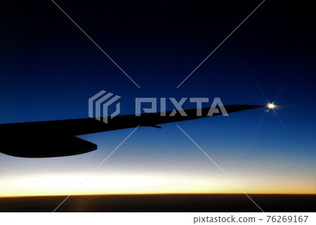 Navigation lamp that shines at dusk as seen from the window of an airplane 76269167