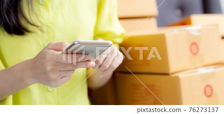 Closeup hand of young asian woman is entrepreneur check order from phone with customer. Closeup hand of young asian woman is entrepreneur check order from phone with customer. 76273137