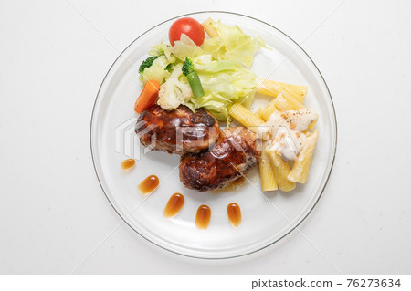 Place hamburger and vegetables on a transparent plate Place hamburger and vegetables on a transparent plate 76273634