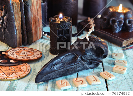 Black candles, runes and witch book on old wooden table.  Esoteric, gothic and occult background, Halloween mystic concept. 76274952