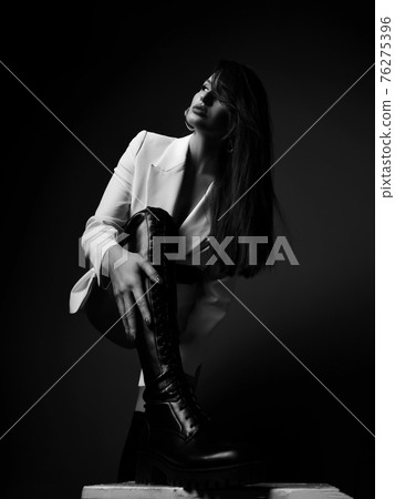 Black and white. Tall sexy woman in white jacket Black and white. Tall sexy woman in white jacket 76275396
