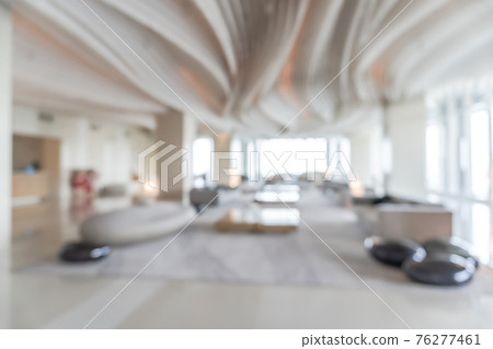 Blurred hotel or office building lobby blur background interior view toward reception hall, modern luxury white room space with blurry corridor and building glass wall window 76277461