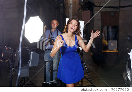 girl on background with photographer during photo shoot girl on background with photographer during photo shoot 76277630