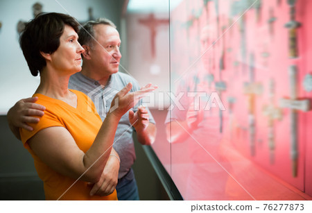 Happy man and woman looking at sculptures 76277873