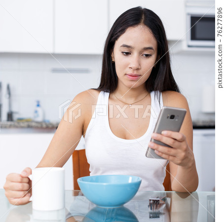 Young girl having breakfast 76277896