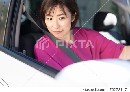 A young woman driving a car 76278147
