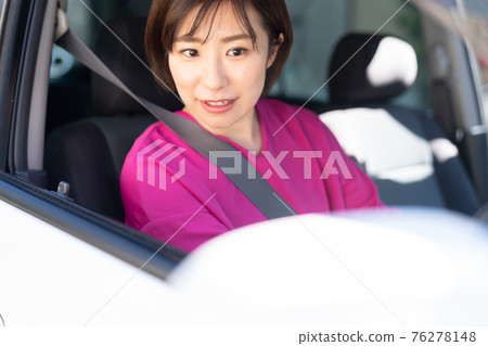 A young woman driving a car 76278148