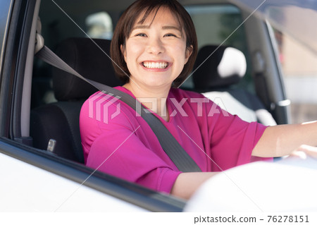 A young woman driving a car 76278151
