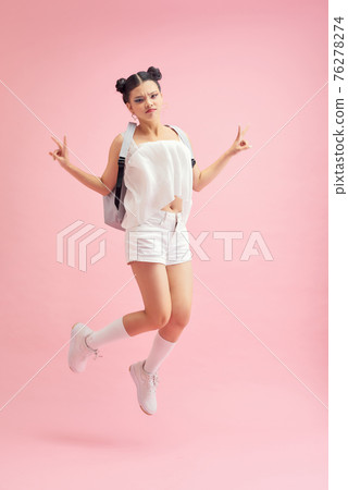 Full length profile photo of funny student lady jumping high showing v-sign symbols wear bag isolated pink color background Full length profile photo of funny student lady jumping high showing v-sign symbols wear bag isolated pink color background 76278274