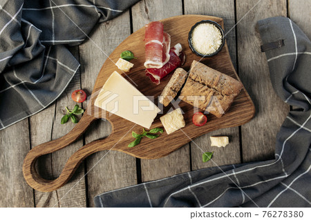Italian cuisine concept. Parmesan Cheese, ham slice, tomato, basil, bread, toast 76278380