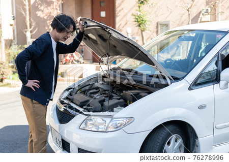 A man in trouble because his car broke down 76278996