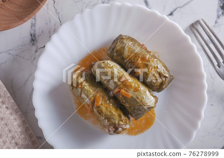Stuffed cabbage rolls in grape leaves. Stuffed cabbage rolls in grape leaves. 76278999