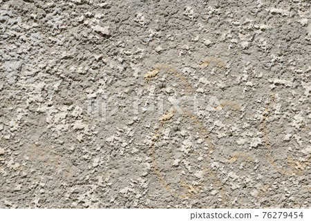 The wall is aged by time with uneven depressions and roughness 76279454