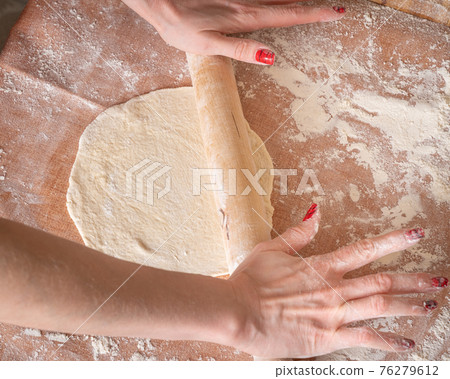 Woman preparing dough for pizza 76279612