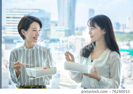 Business woman eating takeaway lunch at the office 76280033