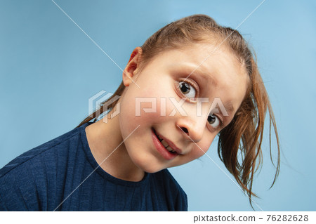 Pretty caucasian girl portrait isolated on blue studio background with copyspace Pretty caucasian girl portrait isolated on blue studio background with copyspace 76282628