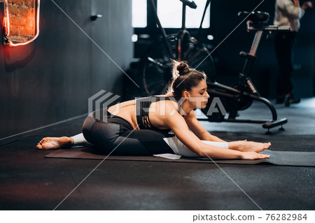 Fitness woman stretching doing pilates stretches exercises Fitness woman stretching doing pilates stretches exercises 76282984
