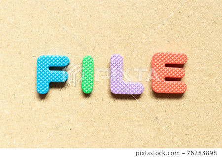 Foam alphabet letter in word file on wood background 76283898
