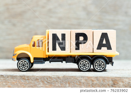 Toy truck hold alphabet letter block in word NPA (Abbreviation of Non performing assets or Nasopharyngeal airway) on wood background 76283902