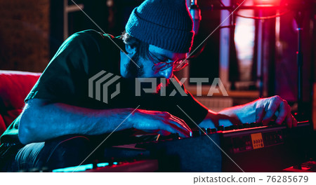 Close-up of musician performing in neon light. Concept of advertising, hobby, music, festival, entertainment. Close-up of musician performing in neon light. Concept of advertising, hobby, music, festival, entertainment. 76285679