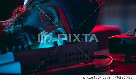 Close-up of musician performing in neon light. Concept of advertising, hobby, music, festival, entertainment. 76285753