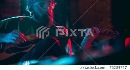 Close-up of musician performing in neon light. Concept of advertising, hobby, music, festival, entertainment. 76285757