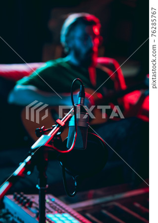 Close-up of musician performing in neon light. Concept of advertising, hobby, music, festival, entertainment. 76285767