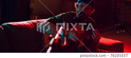 Close-up of musician performing in neon light. Concept of advertising, hobby, music, festival, entertainment. 76285837