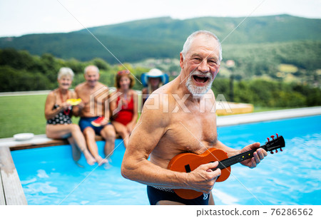 Group of cheerful seniors by swimming pool outdoors in backyard, party concept. Group of cheerful seniors by swimming pool outdoors in backyard, party concept. 76286562