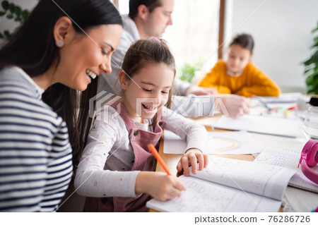 Parents with school girls indoors at home, distance learning. Parents with school girls indoors at home, distance learning. 76286726