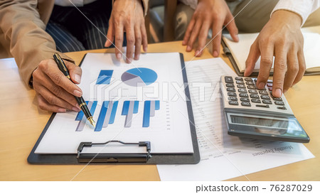 Close-up of businessman hand using calculator to calculate business data, accountancy document at home office. Close-up of businessman hand using calculator to calculate business data, accountancy document at home office. 76287029