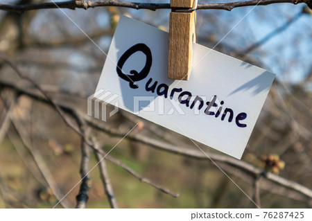 Quarantine word on white card hanging pin spring 76287425