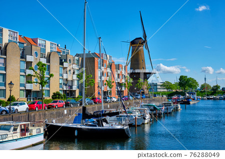 View of the harbour of Delfshaven and the old grain mill De Destilleerketel. Rotterdam, Netherlands 76288049