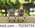 Analog clock in silver shopping cart or a supermarket shopping basket on wooden table. Fast delivery, time value of money concept : depicts the importance of time in our daily life. 76290794