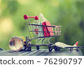 Online shopping, e-commerce concept: Paper shopping bags in a trolley or shopping cart in the natural green background. purchase of products on internet can purchase goods from foreign countries 76290797