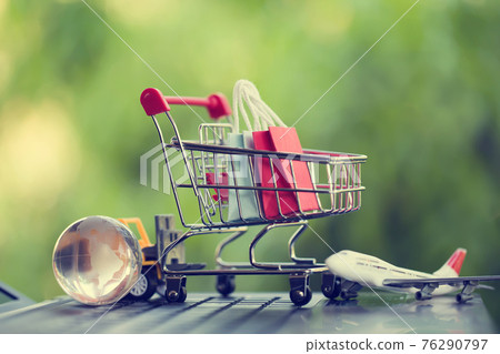Online shopping, e-commerce concept: Paper shopping bags in a trolley or shopping cart in the natural green background. purchase of products on internet can purchase goods from foreign countries Online shopping, e-commerce concept: Paper shopping bags in a trolley or shopping cart in the natural green background. purchase of products on internet can purchase goods from foreign countries 76290797