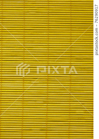 Wooden blinds on the mustard-colored windows.Texture or background 76290917