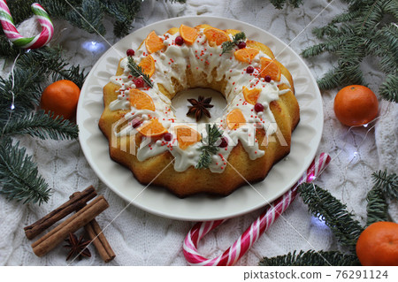 New year's cupcake is decorated with a slice of tangerine and a coniferous twig New year's cupcake is decorated with a slice of tangerine and a coniferous twig 76291124