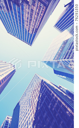 Looking up at Manhattan skyscrapers, color toned picture, New York City, USA. 76291850