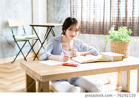 Young woman studying in the living room Young woman studying in the living room 76292110