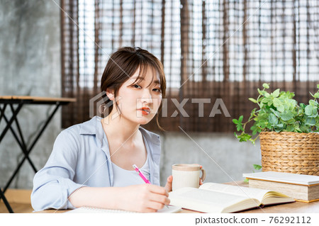 Young woman studying in the living room Young woman studying in the living room 76292112