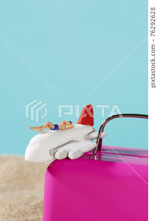 airplane and miniature man on a suitcase airplane and miniature man on a suitcase 76292628