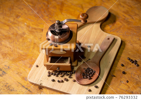 ..Manual coffee grinder placed on a wooden floor. ..Manual coffee grinder placed on a wooden floor. 76293332