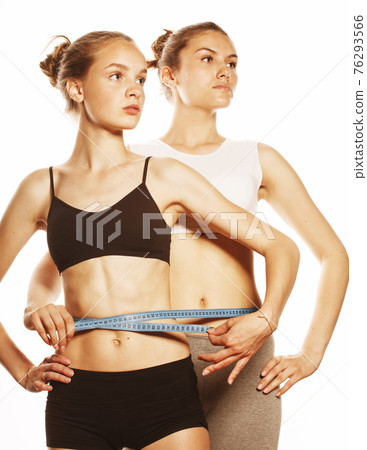 two sport girls measuring themselves isolated on white two sport girls measuring themselves isolated on white 76293566